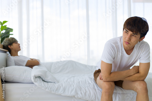 Homosexual or gay couple relationship problems on bed.