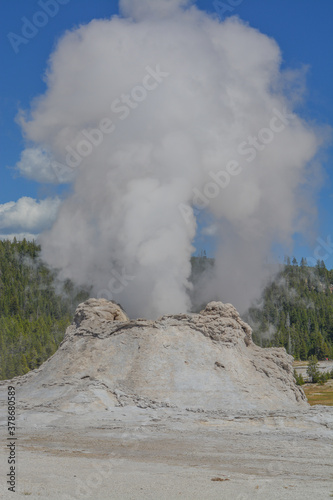 This is Castle Geyser erupting in the Upper Geyser Basin. This massive cone erupts scalding watering has a huge mineral formation. It is one of Yellowstone Nation Parks amazing attractions. 