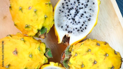 Top view Rotate of Yellow Pitahaya dragon fruit on wooden background, Sweet yellow dragonfruit Pitahaya with slices on wooden plate.