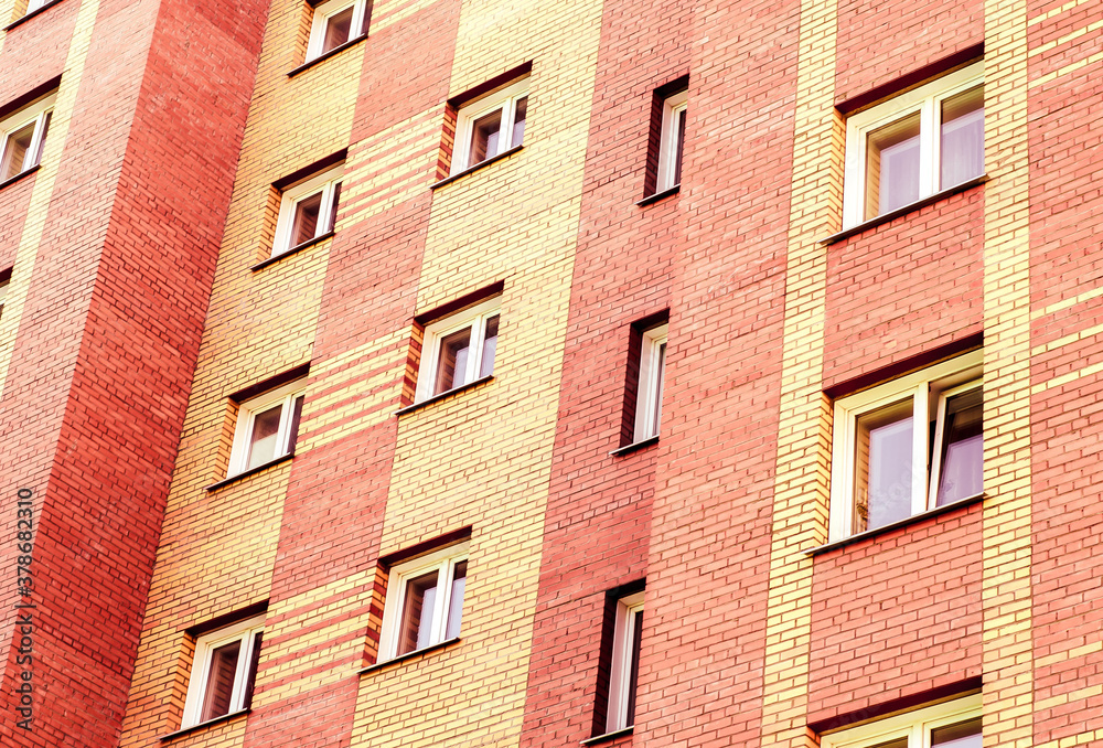 Fototapeta premium The facade of a new multi-storey residential building is built of brick. Residential apartment building. Housing.