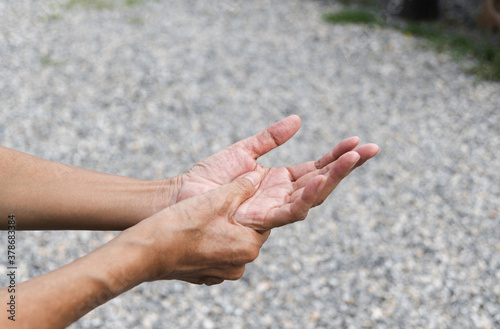 Closeup hand of person massage her hand from pain in healthy concept on nature background. © mintra