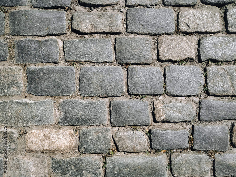 Texture of dark gray granite paving stones, top view. Background from natural block stone. Texture of dark gray granite paving stones, top view. Background from natural block stone.