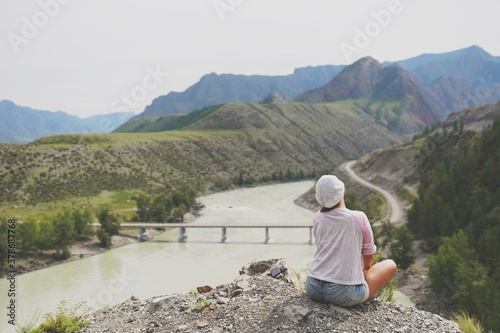 person sitting on the edge of the mountain