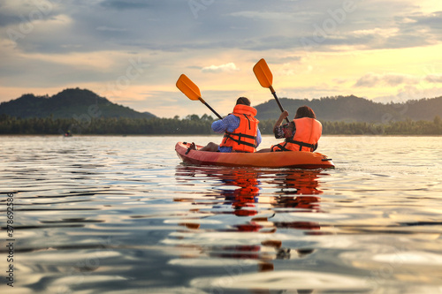 Tourist paddling the kayak on the sea among the beautiful scenery during sunset at koh pitak , chumphon province in Thailand. This is very popular for photographers and tourists. photo