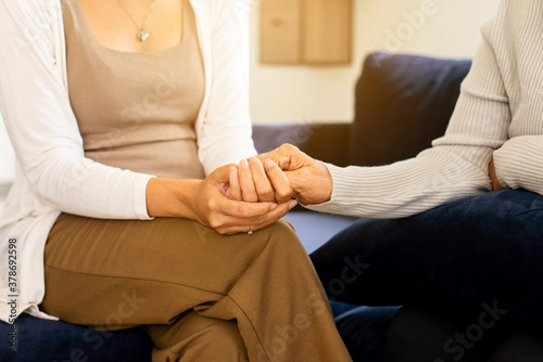 Caregiver woman holding hands to elderly with alzheimer disease at home,Adult social care concept