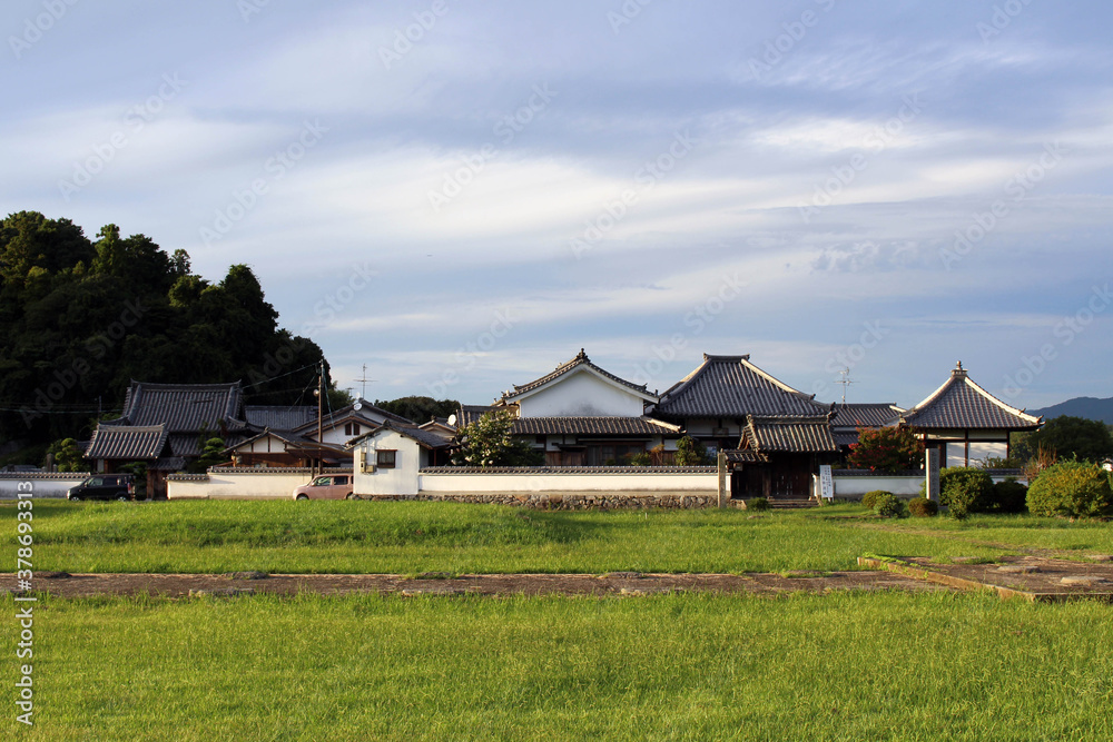 Green field and traditional house in a village of Asuka