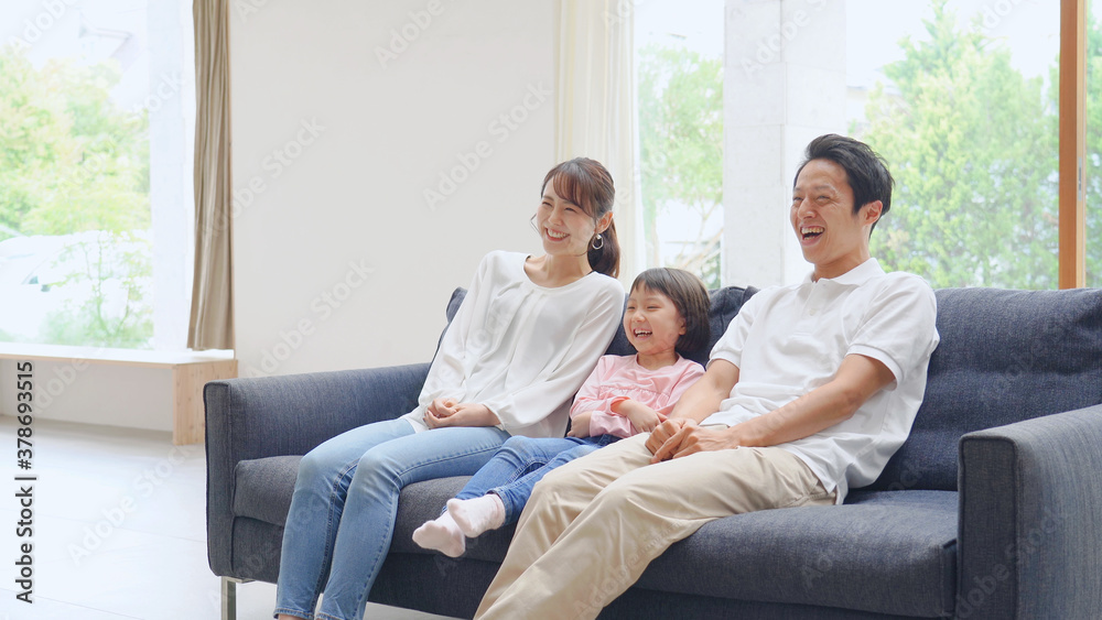 ソファーで笑う家族 ソファーで笑う家族