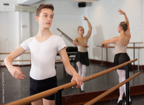 Slim young man rehearsing ballet dance in studio. High quality photo