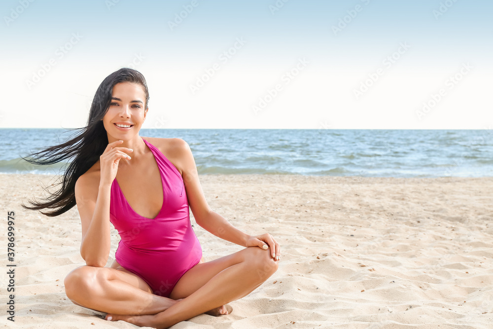 Beautiful young woman in swimsuit on sea beach