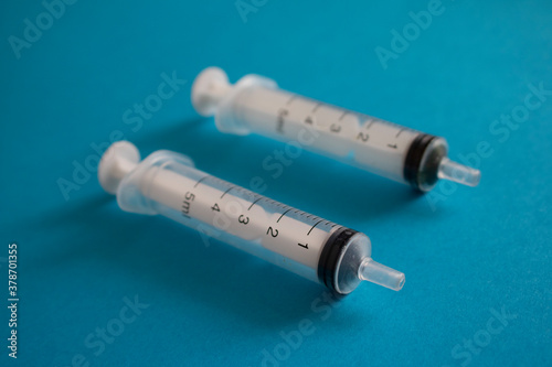 Injection with two syrings on blue paper,