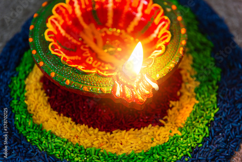 Close up clay lit light a fire already on Diya or oil lamp on concrete background, Decoration of Hinduism rangoli, Happy celebration Deepavali, or Diwali Indian festival concept