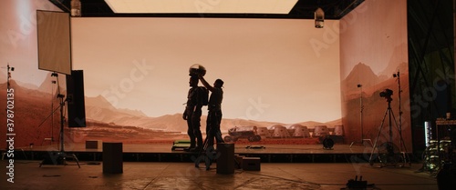 Fotografia Behind the scenes shot of virtual production stage with huge LED screens, cinematorgapher shooting Mars scene