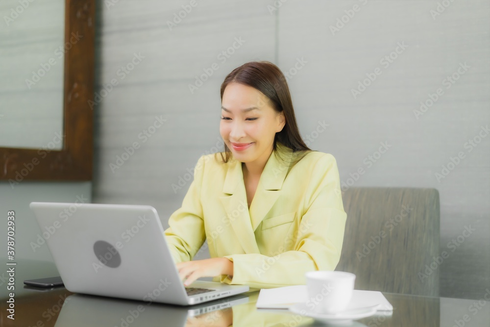 Portrait beautiful young asian woman use computer laptop with smart mobile phone on working table Portrait beautiful young asian woman use computer laptop with smart mobile phone on working table