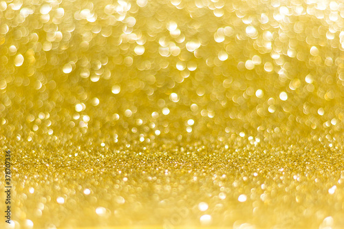 Golden sparkle glitters with bokeh effect and selectieve focus. Festive background with bright gold lights, champagne bubble. Christmas mood concept. Copy space, close up, texture, top view.