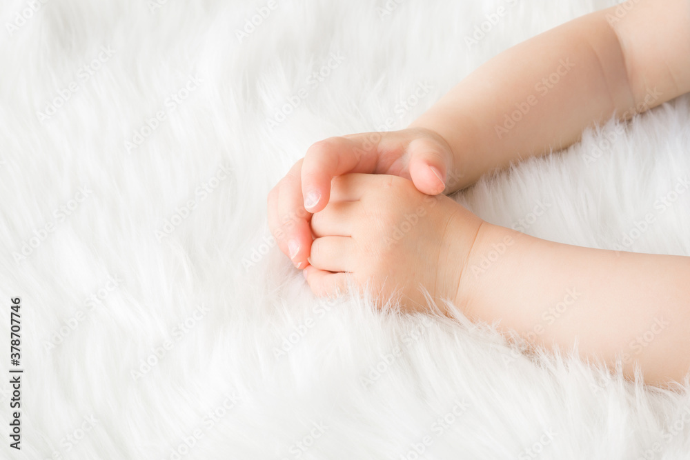 Baby girl hands on white, soft, fluffy fur blanket. Closeup. Baby girl hands on white, soft, fluffy fur blanket. Closeup.