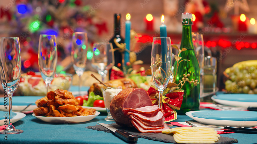 Delicious traditional food for christmas gathering on the table. Xmas celebration in decorated room full of globe decorations and christmas tree with fireplace, big festive dinner meal for large