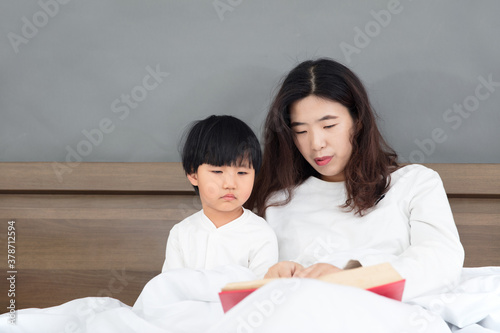 Mother who gets up early in bed and cultivates her daughter's interest in reading