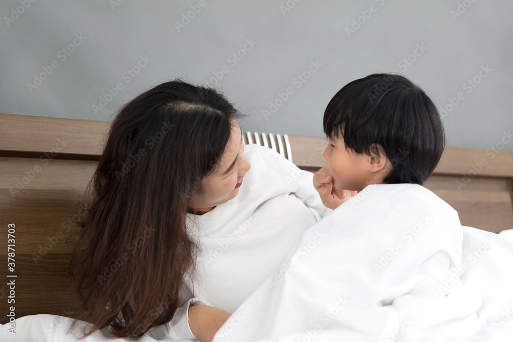 Beautiful mother and cute child playing in the bedroom Beautiful mother and cute child playing in the bedroom