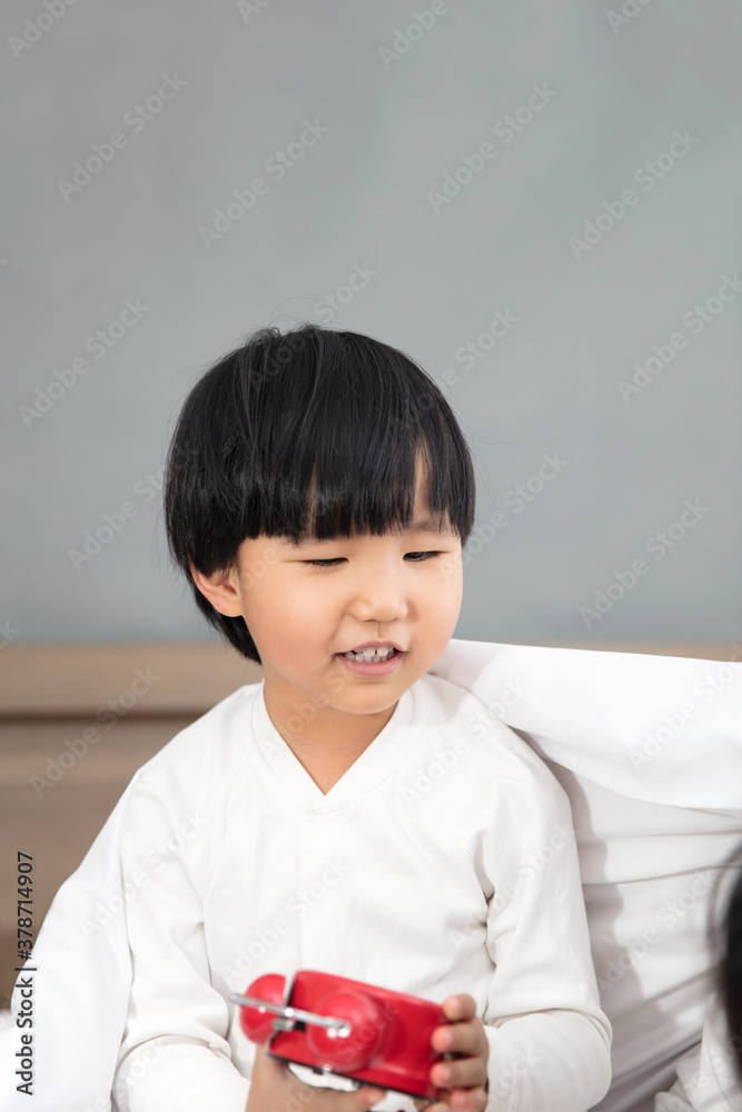 Cute child sets the alarm clock before going to bed Cute child sets the alarm clock before going to bed
