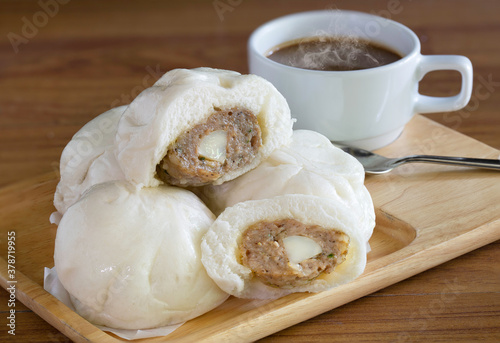 amed bun and hot coffee in the wooden tray Chinese snack on brown wooden table