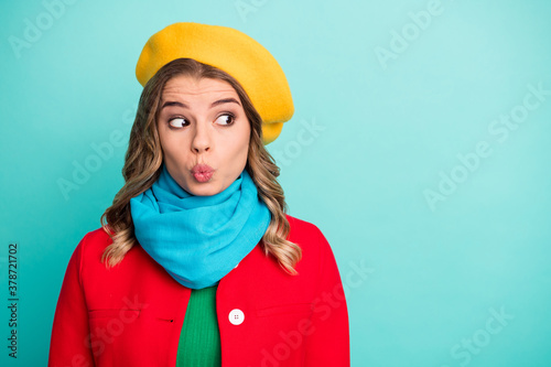 Portrait of funny funky cute girl wait for her boyfriend astonished look copyspace send air kiss wear bright stylish trendy outerwear isolated over turquoise color background © deagreez