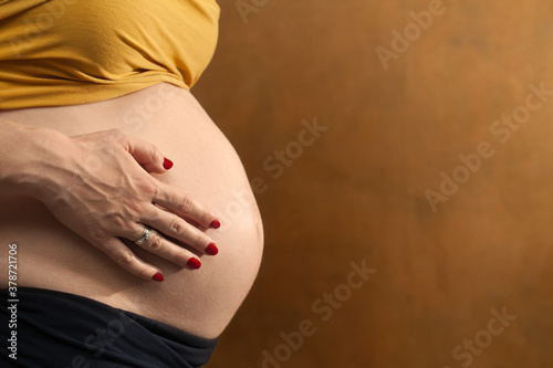 Kobieta w ciąży obejmująca swój brzuch.