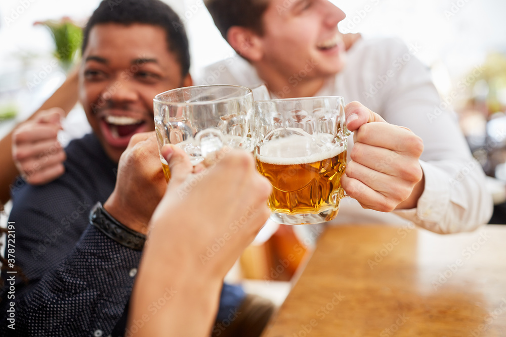 Männer trinken Bier und prosten sich zu im Biergarten Männer trinken Bier und prosten sich zu im Biergarten