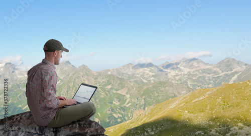 man working remotely outdoors with laptop © andreusK