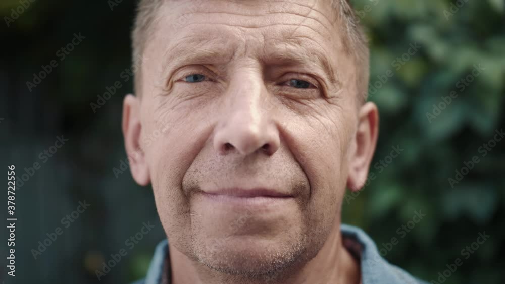 Close up portrait of mature businessman smiling confident enjoying success. Face of attractive senior man close up. Elderly male looking at the camera and smiling.