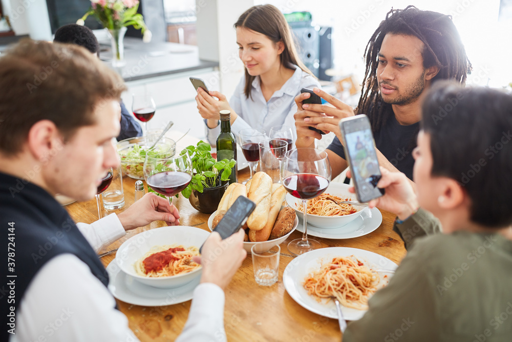 Gruppe Leute beim Essen schaut auf Smartphone Bildschirm