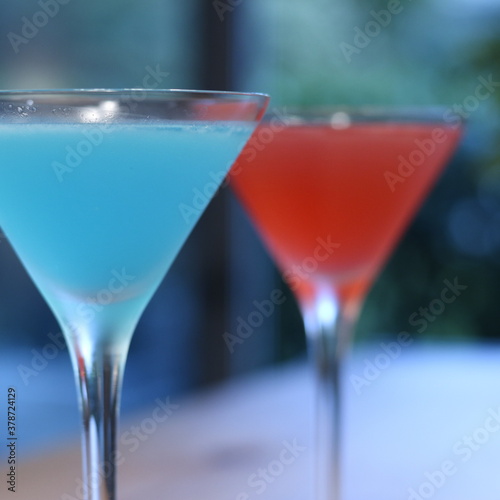 Cosmopolitan and Blue Lagoon cocktail in Martini glass close shot on window background