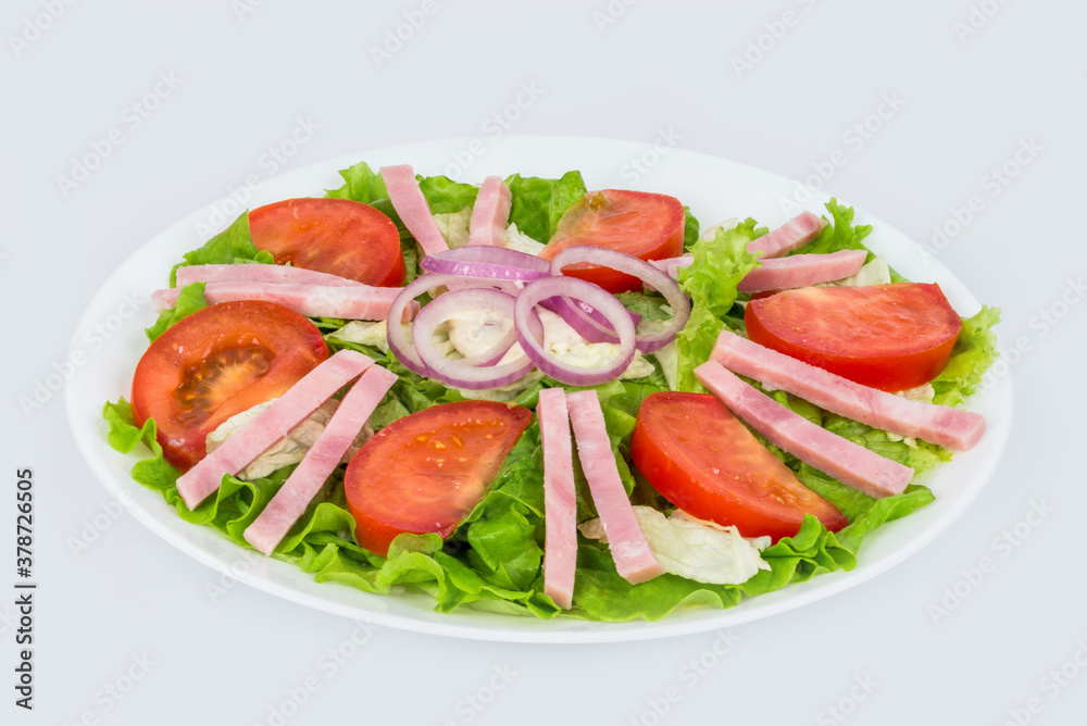 Salad in a white plate with ham, fresh tomatoes and herbs