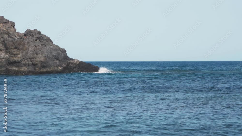 Powerful sea waves crashing into the rocky shore of a beach splashing everywhere. Powerful sea waves crashing into the rocky shore of a beach splashing everywhere.
