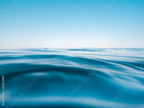 Skyline with blue sky and underwater part with sea and waves.
