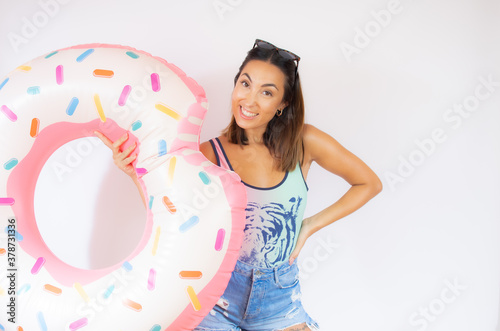 Woman looking at the camera with a happy expression while holding a giant doughnut with a bite