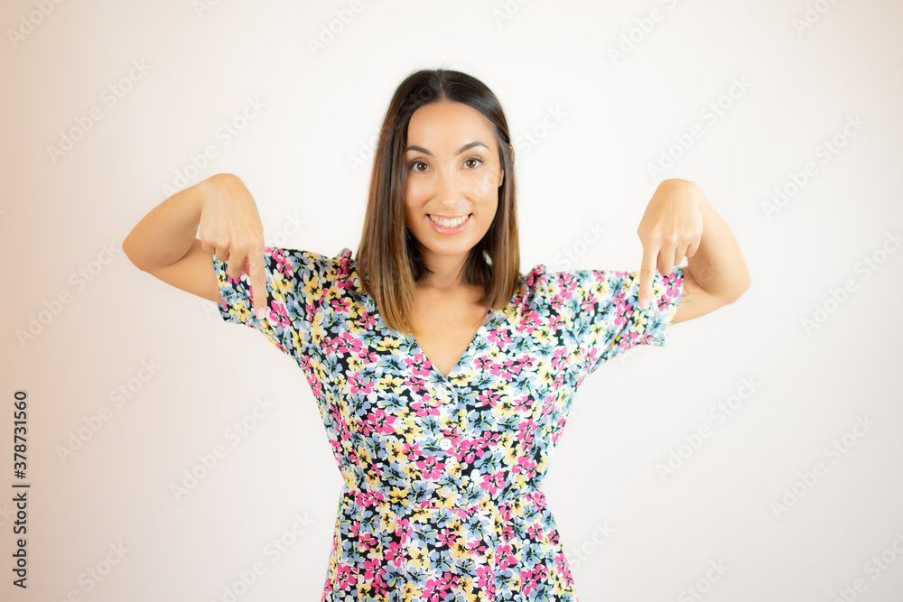 Woman standing pointing to the ground while facing the camera Woman standing pointing to the ground while facing the camera