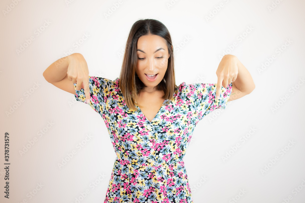 Woman in flower dress standing pointing to the ground Woman in flower dress standing pointing to the ground