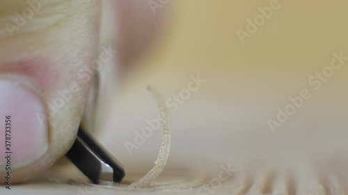 macro shooting. woodcarver carves letters on a wooden board with a chisel .Woodworking concept.