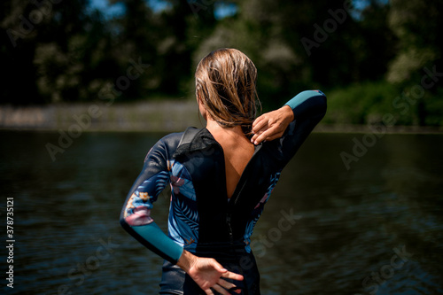 Rear view of woman in wetsuit with the zipper open.