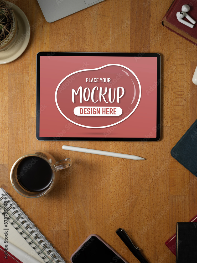 Naklejka premium Mock up tablet on wooden desk with supplies and stationery