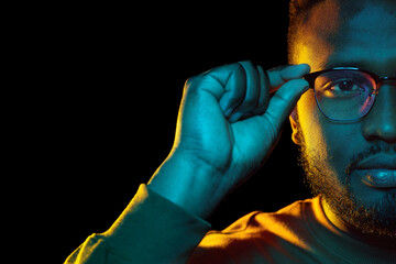 people and ethnicity concept - portrait of young african american man in glasses over black background