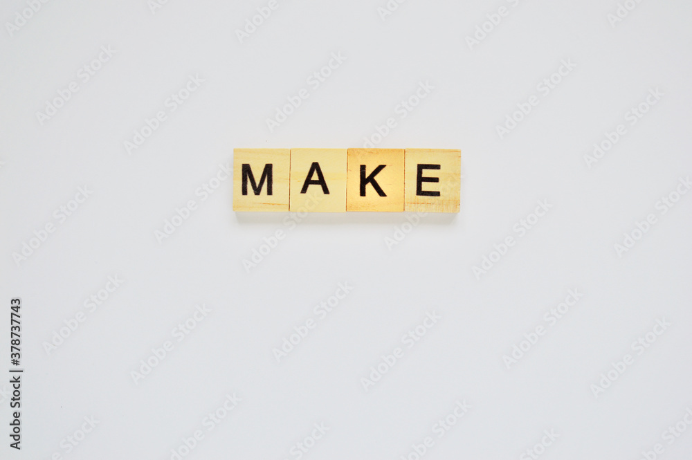 Word make. Wooden blocks with lettering on top of white background. Top view of wooden blocks with letters on white surface Word make. Wooden blocks with lettering on top of white background. Top view of wooden blocks with letters on white surface