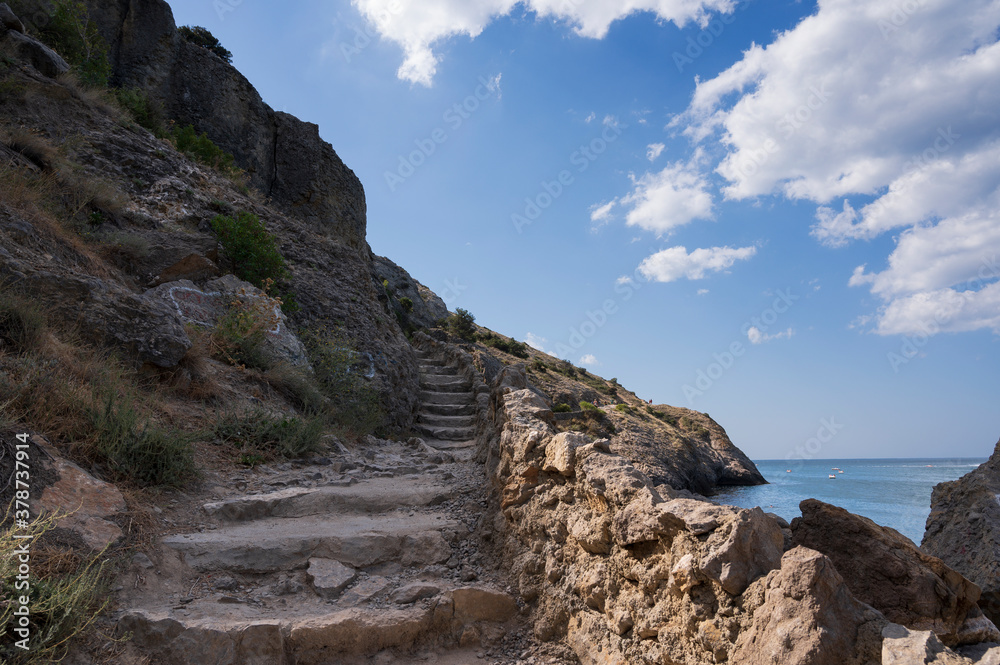 stairs leading to the mountains, blue sky and sea