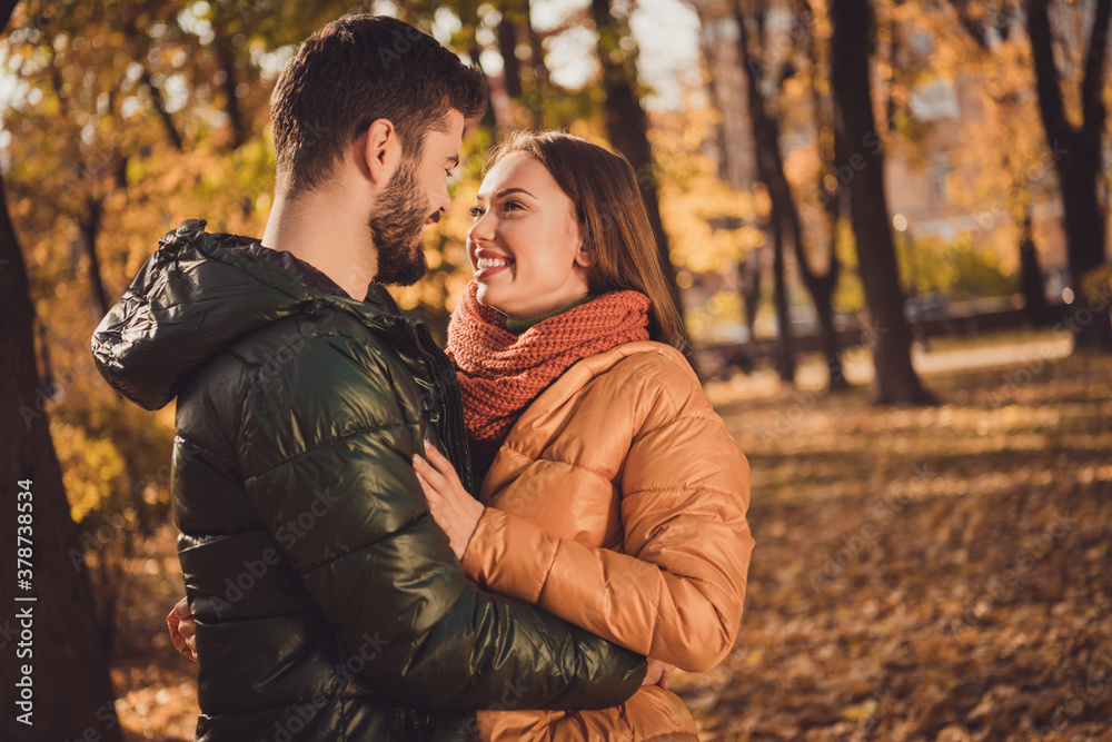 Fototapeta premium Photo of affectionate charming couple guy hug his girlfriend in autumn outdoors town park