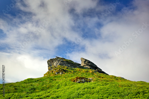 Petrovy kameny in Jeseniky mountain  Czech Republic  Europe. Green rocky hill with stone. Blue sky with white clouds. Summer day in the mountain.