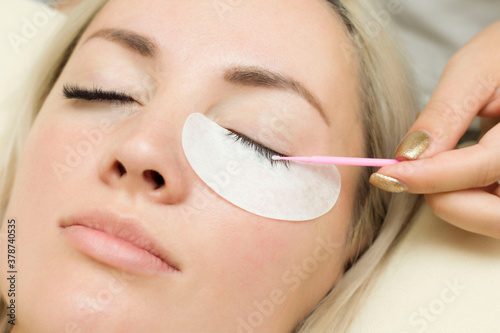 master lashmaker performs eyelash degreasing . Eyelash extension procedure. Microbrush photo