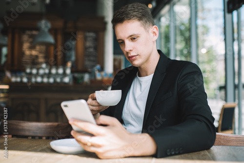 Young man using smartphone in cafe