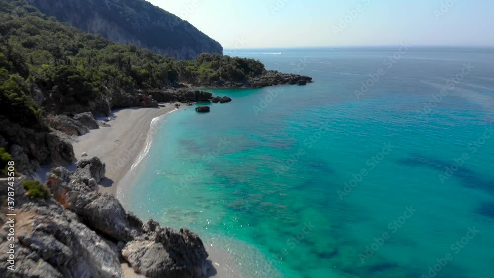 Secret sandy beach bordered by rocks and green hills washed by clean turquoise sea water Secret sandy beach bordered by rocks and green hills washed by clean turquoise sea water