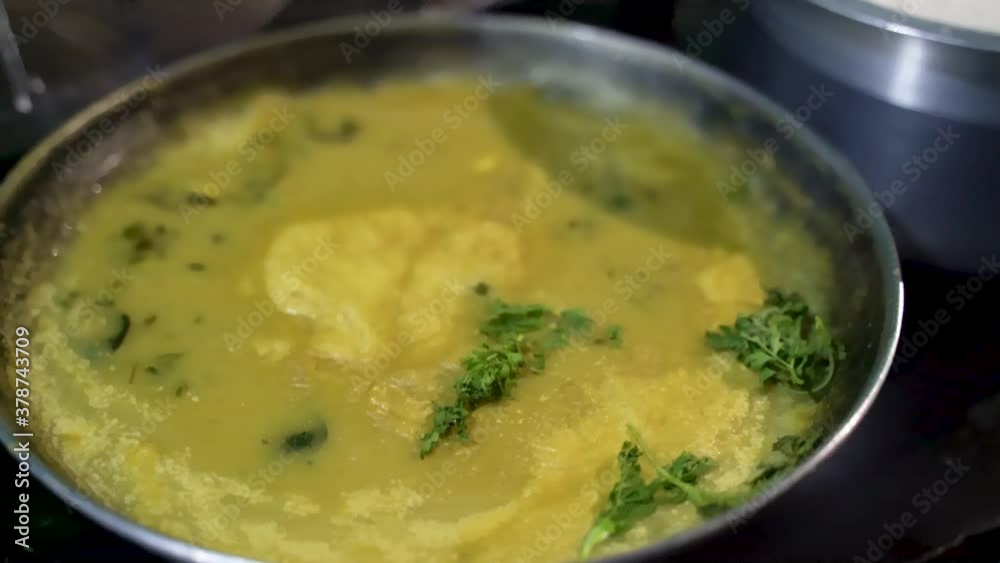 Cooked Maharashtrian Kadhi In A Pan Garnish With Fresh Green Herbs. - Close Up Shot Cooked Maharashtrian Kadhi In A Pan Garnish With Fresh Green Herbs. - Close Up Shot