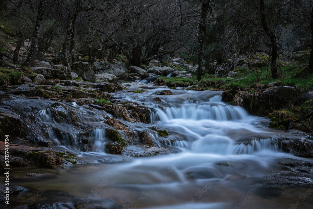 River water flows among the rocks and forms small waterfalls, Rascafría, Madrid, Spain River water flows among the rocks and forms small waterfalls, Rascafría, Madrid, Spain